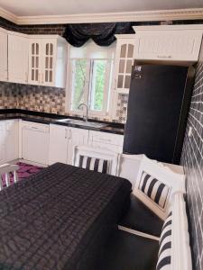 uma cozinha com uma cama, armários brancos e um lavatório. em Hânetül Mabeyn em Rize