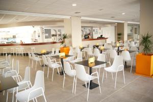 a restaurant with white tables and white chairs at Ohtels Villa Dorada in Salou