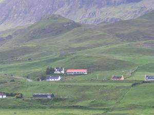 a group of houses on a green hillside at Skye Stays in Staffin