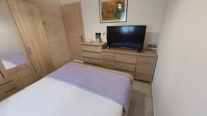 ein kleines Schlafzimmer mit einem Bett und einem TV in der Unterkunft Holiday Home Matthäus am Corfutrail, Ferienoase im Olivenhain 3 km zum Meer in Giannádes