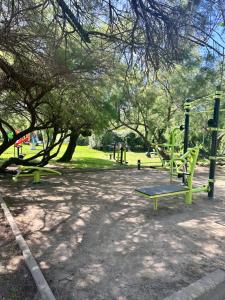 un parc avec deux balançoires et un arbre dans l'établissement Village Vacances La Vallicella, à Poggio-Mezzana