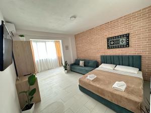 ein Schlafzimmer mit einem Bett und einer Ziegelwand in der Unterkunft TreA Accomodations - Suite port in Vlorë