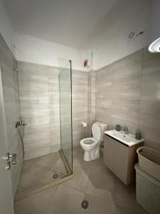 ein Badezimmer mit Dusche, Toilette und Waschbecken in der Unterkunft TreA Accomodations - Suite port in Vlorë