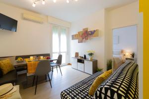 a living room with a bed and a dining room at La Perla del Sole - Sunset on the beach in Lido di Pomposa