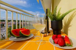 a table with two plates of fruit and a glass of wine at La Perla del Sole - Sunset on the beach in Lido di Pomposa