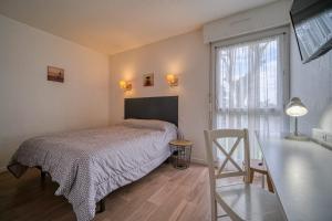 1 dormitorio con cama, escritorio y ventana en Hotel Coté Sud en Saint-Péray