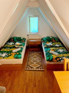 2 Betten in einem Zimmer mit Dachgeschoss in der Unterkunft Favilla DELUXE Bogács in Bogács