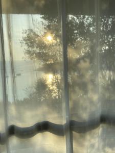 Una mujer mirando por una ventana al atardecer en LOOK Bungalows, en Ko Tao