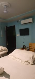 a bedroom with a white bed and a blue wall at Hotel Diamond in Bharatpur