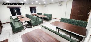 a restaurant with wooden tables and green chairs at Hotel Nova Shapar in Rabda