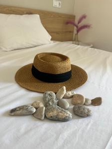a straw hat and rocks on a bed at House Kohili in Nea Vrasna