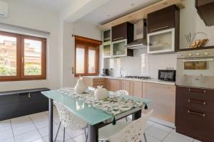a kitchen with a table with chairs and a counter top at La Casetta-10 min Aeroporto e spiaggia in Fiumicino
