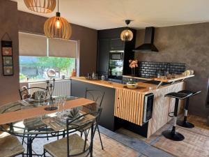 a kitchen with a table and chairs and a counter at Well & S Spa privatif in Hensies
