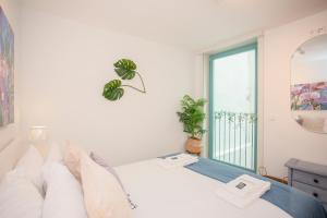 biała sypialnia z łóżkiem i oknem w obiekcie Liiiving in Porto - Boho Blue Home w Porto