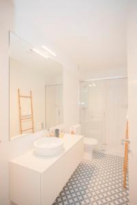 biała łazienka z umywalką i toaletą w obiekcie Liiiving in Porto - Boho Blue Home w Porto