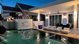 una piscina con dos cisnes en una casa en พลอยพูลวิลล่า ชะอำ 3 Ploy Poolvilla Cha-am 3, en Cha Am