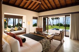 タンガラにあるAnantara Peace Haven Tangalle Resortのベッドルーム1室(ベッド1台付)、リビングルームが備わります。