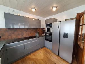 a kitchen with stainless steel appliances and wooden floors at Duplex près des Thermes avec jardin in Évian-les-Bains +8 photos