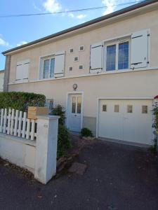 une maison blanche avec deux portes de garage et une clôture dans l'établissement Maison 6 chambres avec jardin à Angers, à Angers