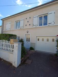 Biały dom z dwoma drzwiami garażowymi i ogrodzeniem w obiekcie Maison 6 chambres avec jardin à Angers w mieście Angers