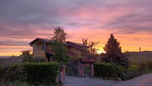 a house with a sunset in the background at Casa Arcobaleno Holiday home apartments in Diano dʼAlba