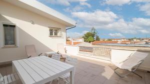 Un patio con una mesa y sillas en un balcón. en La Casa di Anita, en Orosei