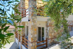 una casa con un pilastro di pietra e una porta di Helicon Luxury Villas a Limenas
