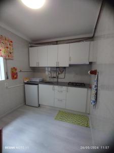 a kitchen with white cabinets and a sink at Apartamentos das Avós-Bélise in Nazaré