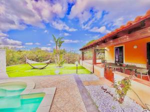 a house with a pool and a hammock at Villa indipendente in Altavilla Milicia