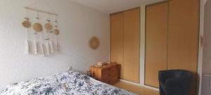 a bedroom with a bed and a wooden cabinet at Rêve de Bisca Appartement spacieux avec jardin privatif piscine et parking privés in Biscarrosse +98 photos