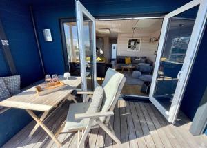 a room with a table and chairs and a living room at Hausboot LUMME - Huus & Meer in Großenbrode-Kai +17 photos