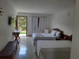um quarto de hotel com duas camas e uma janela em Pousada Água de Fuego em Maragogi