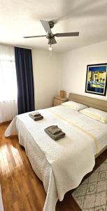 1 dormitorio con 1 cama blanca grande y ventilador de techo en Apartments Ivana en Sutivan