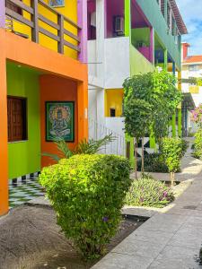 a colorful building with bushes in front of it at Hotel Marujo in Morro de São Paulo