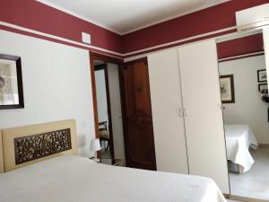 a bedroom with a white bed and a mirror at D&P Apartments Suites 2 Salemi in Salemi