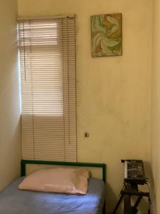 Kos Omah Yanto 19 في جاكرتا: غرفة نوم بها سرير ونافذة بها هاتف