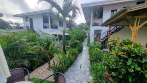 un camino que conduce a un edificio con plantas y flores en Ballena Rey Hotel en Uvita