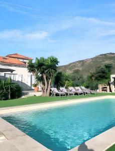uma piscina com cadeiras e uma casa em Villa de 5 chambres avec vue sur la mer piscine privee et jardin clos a Saint Florent em Saint-Florent