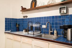 a kitchen counter with a sink and blue tiles at Beach Pad w Patio, walk to everything! GEN AC - 20 Down in San Juan +24 photos
