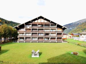 Studio Morzine, 1 pièce, 4 personnes - FR-1-524-69 في مورزين: مبنى كبير أمامه حقل أخضر