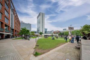 people walking around a park in a city at Central Piccadilly Luxury Three Bedroom Apartment in Manchester