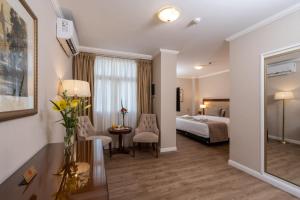 Hotel Intersur Recoleta في بوينس آيرس: غرفة فندقية بسرير وطاولة وكراسي