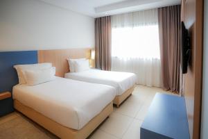 a hotel room with two beds and a window at Zephyr Agadir in Agadir