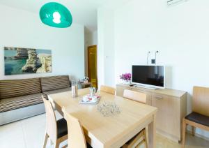 a dining room with a table and a couch at Iria Residence in Torre dell'Orso
