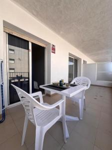 a white table and chairs in a room with a window at APCOSTAS Els Pins Lotus in Blanes