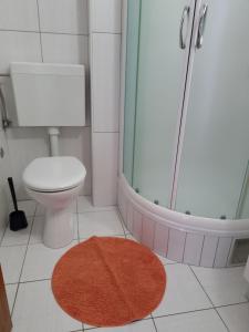 La salle de bains est pourvue de toilettes, d'une douche et d'un tapis. dans l'établissement Villa Oliva, à Makarska