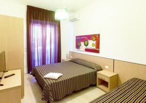 a hotel room with two beds and a window at Iria Residence in Torre dell'Orso