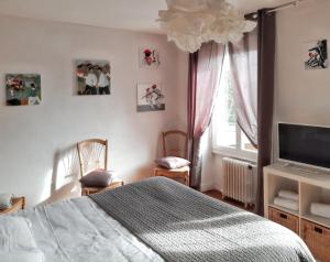 1 dormitorio con 1 cama, TV y ventana en Maison de 4 chambres avec piscine privee et wifi a Saint Germain du Pert a 5 km de la plage, en Saint-Germain-du-Pert