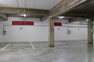 uma garagem vazia com paredes brancas e aberturas vermelhas em Hotel Eurosol Alcanena em Alcanena