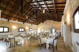 jadalnia ze stołami i krzesłami w budynku w obiekcie Masseria Corda Di Lana Hotel & Resort w mieście Torre Lapillo